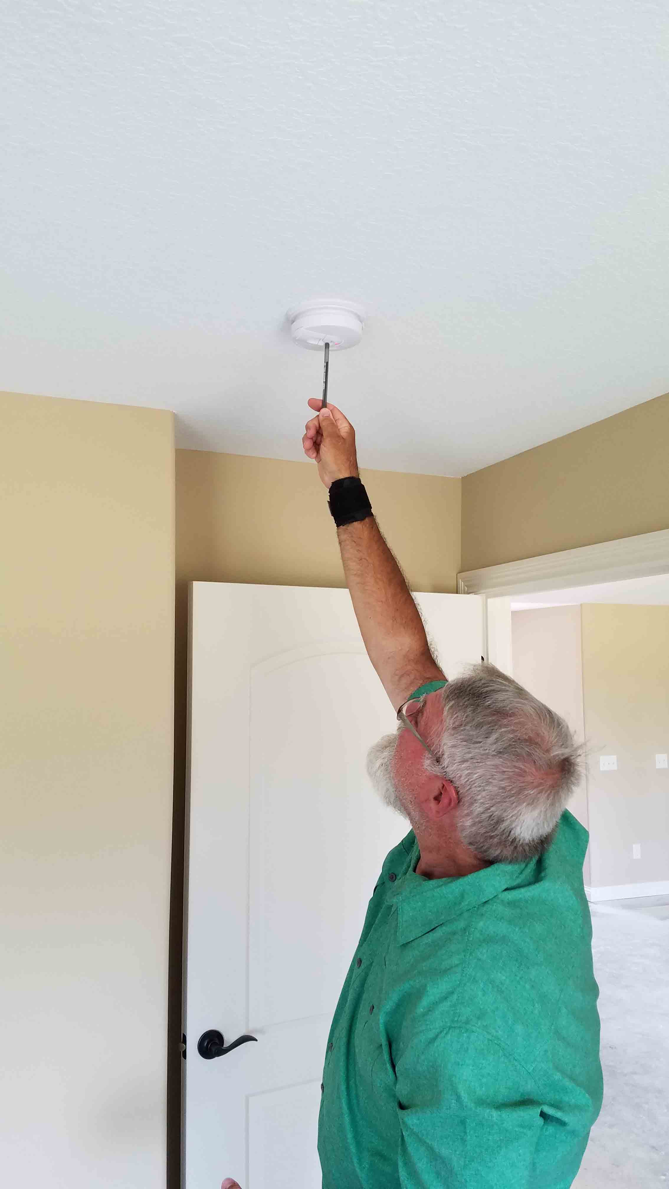 Building Commissioner Testing Smoke Alarm